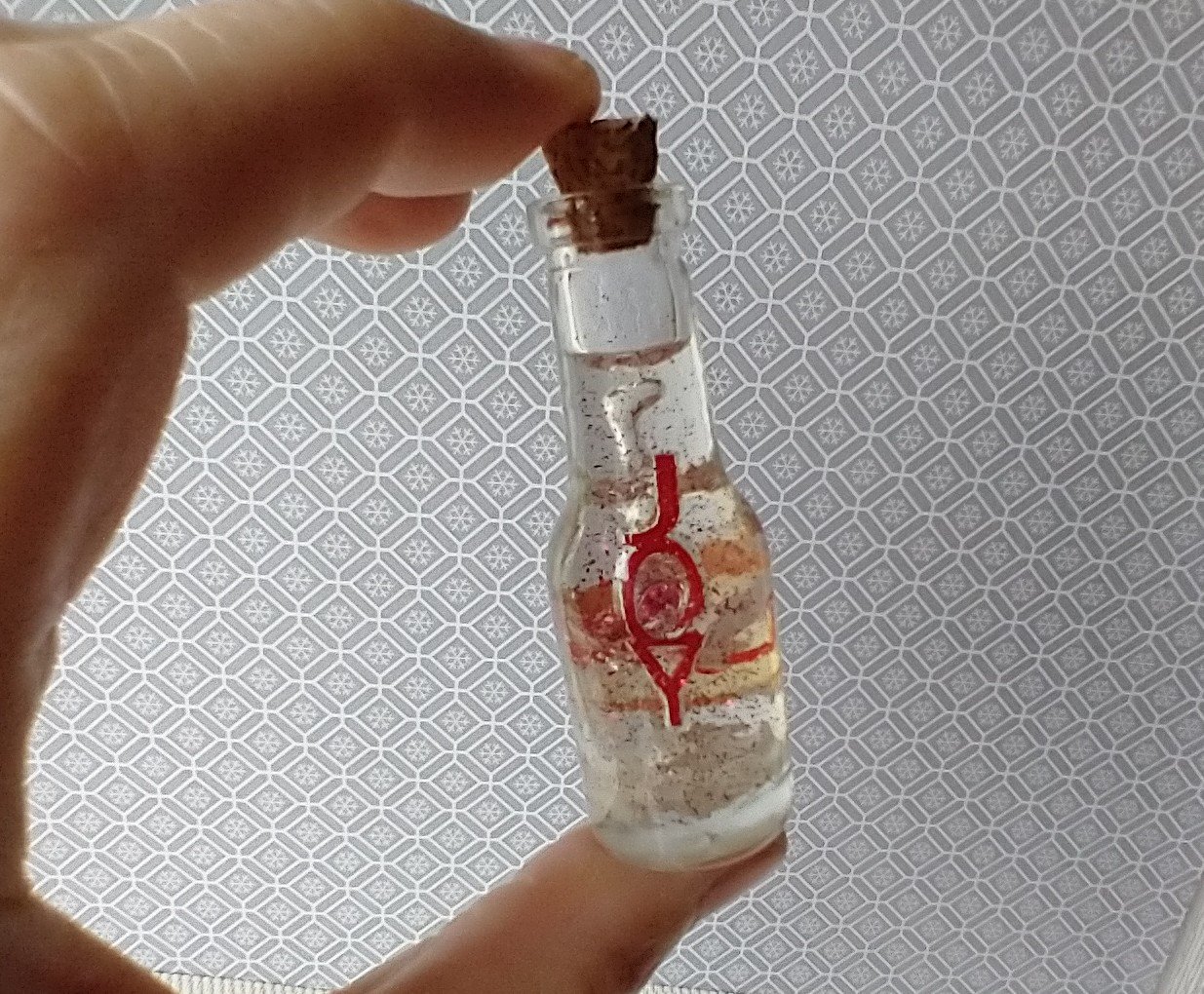 Dollhouse miniature battery lighted glass bottle red glitter glow-in-the-dark cutouts and abstract JOY ornament inside bottle for 12th or play scale dioramas No external wires