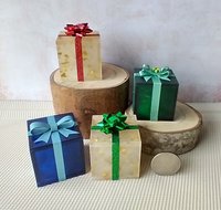 Miniature light up gift box in translucent blue with a light blue shimmery gift bow Battery lighted festisve gift box for mini holiday scene display REF Blue