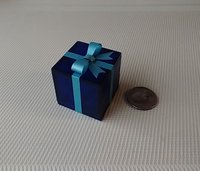 Miniature light up gift box in translucent blue with a light blue shimmery gift bow Battery lighted festisve gift box for mini holiday scene display REF Blue