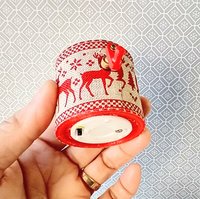 Miniature merry go round hand crank automaton with ligt up cream lidded mug and a parade of gingerbread people, ribbon candy, cupcake and French macarons