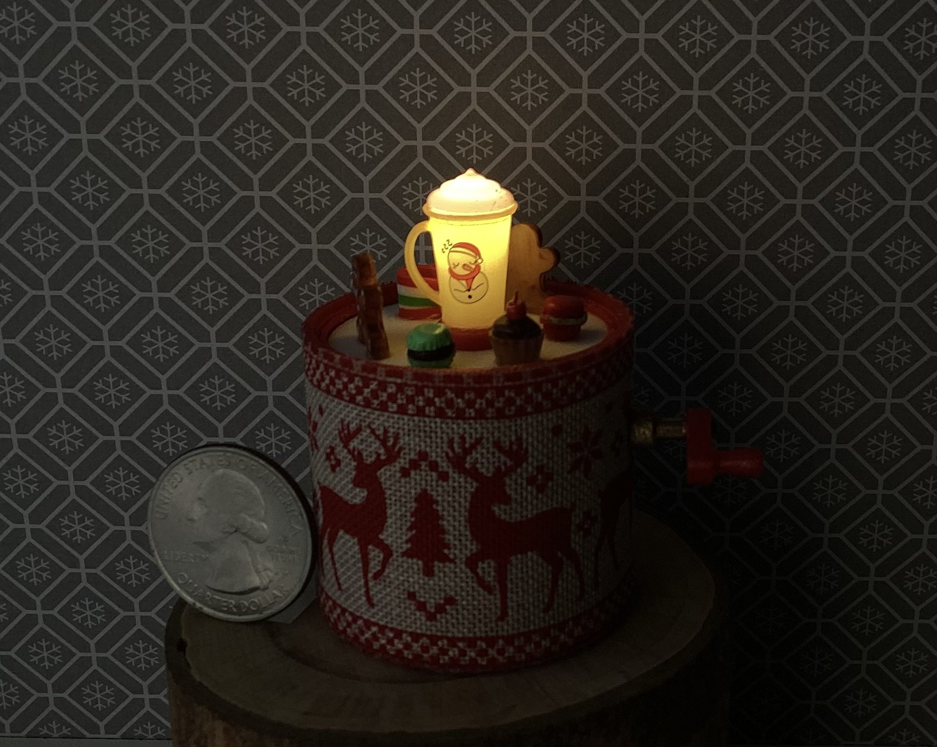 Miniature merry go round hand crank automaton with ligt up cream lidded mug and a parade of gingerbread people, ribbon candy, cupcake and French macarons