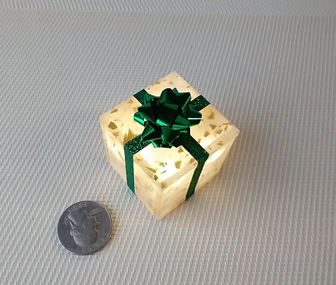 Miniature light up gift box in golden flakes with a green gift bow Battery lighted festive gift box for mini holiday scene display REF Golden flake green bow