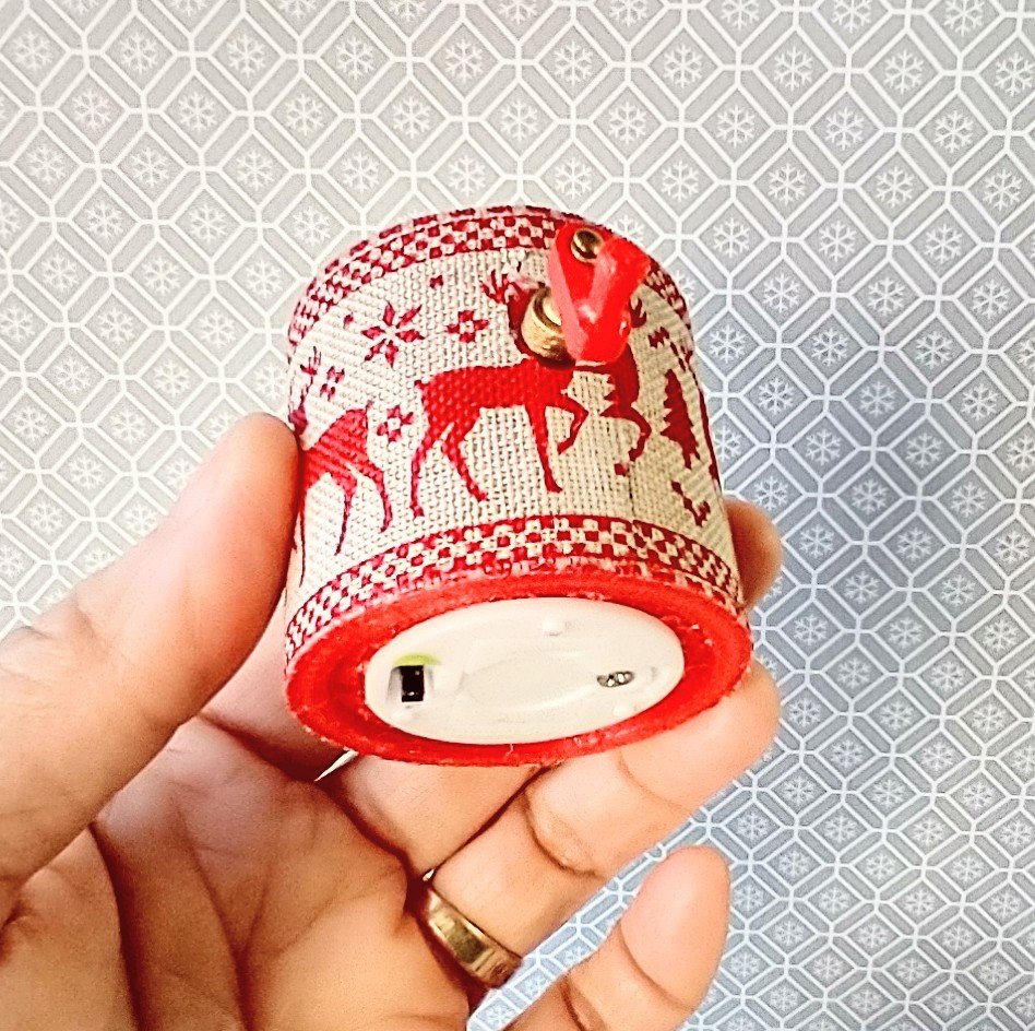 Miniature merry go round hand crank automaton with ligt up cream lidded mug and a parade of gingerbread people, ribbon candy, cupcake and French macarons