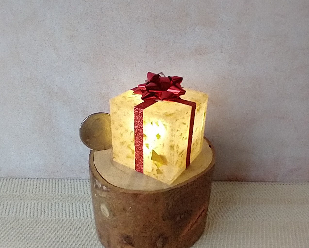 Miniature light up gift box in golden flakes with a  red gift bow Battery lighted festive gift box for mini holiday scene display REF Golden flakes red bow