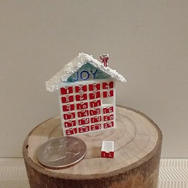 1:12 Dollhouse advent calendar with JOY sign above the twenty-four openable drawers REF Mere JOY